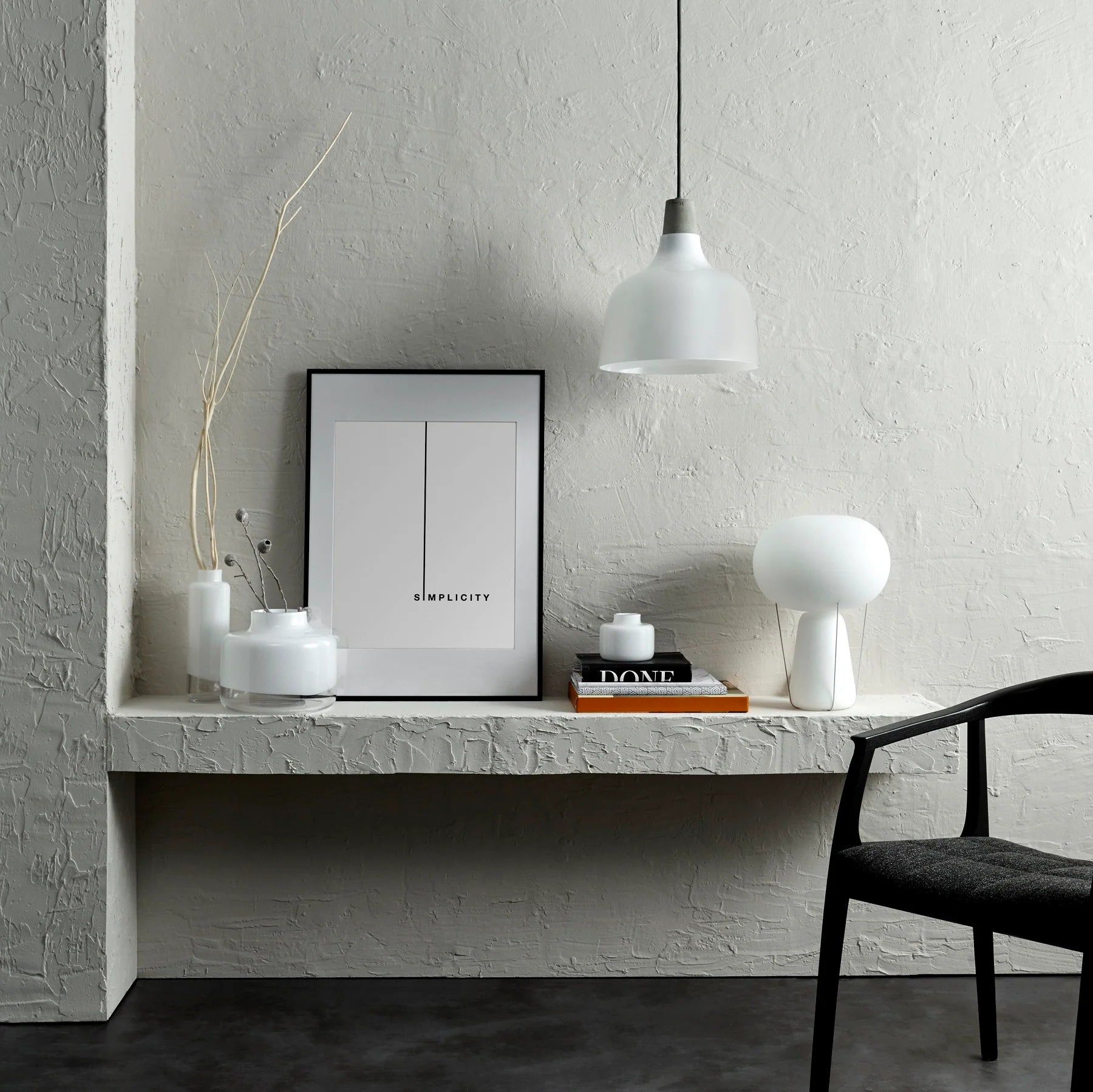 opal hvid bordlampe blow i en stue der er lavet at flotte grå sten vægge