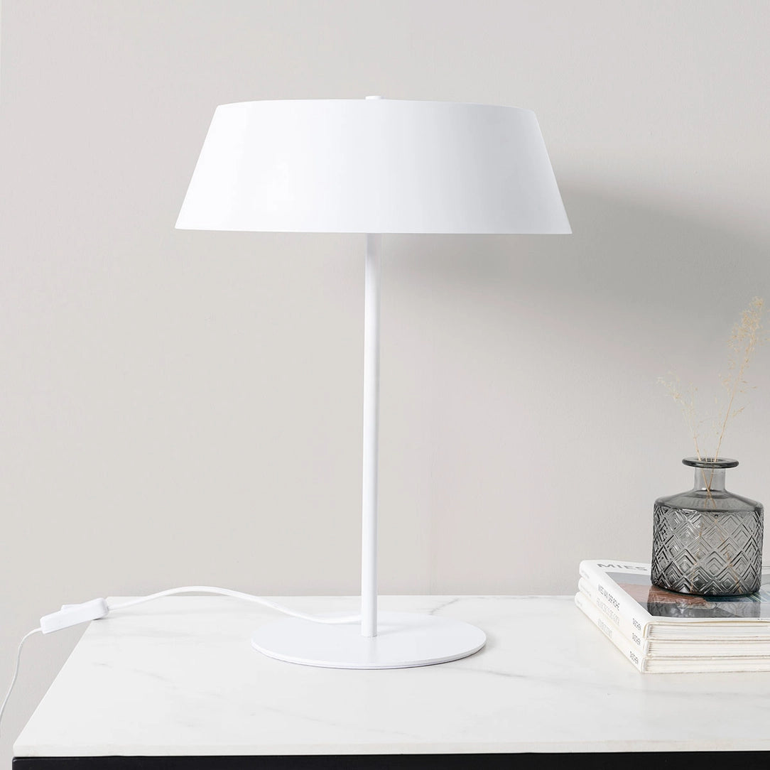 den hvide metal lampe liva der står på et hvidt skrivebord