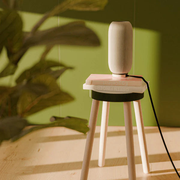 Bordlampen Pille der står på en skammel i et flot rum med grønne vægge lampen er 3d printet og i papir  design